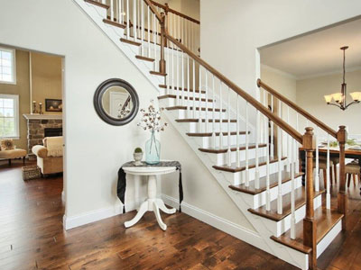 white staircase with walnut colored steps and railing